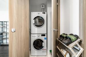 a washer and dryer sitting next to a door at Bright & Cozy 1BR Steps to Brentwood mall in Burnaby