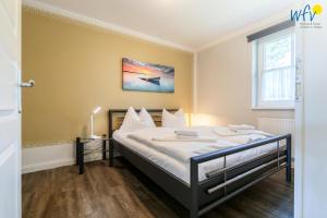a bedroom with a large bed with white sheets at Haus Wreechen Ferienwohnung Michaelis in Putbus