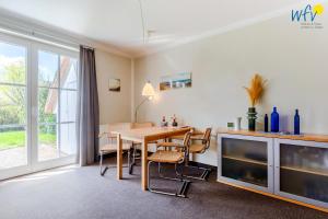 a dining room with a table and a tv at Haus Wreechen Ferienwohnung Michaelis in Putbus