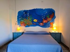 a bedroom with a bed with a painting on the wall at Lu Lisandru in Abbiadori