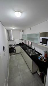 a small kitchen with a sink and a stove at Pardelas playa y ballenas in Puerto Madryn
