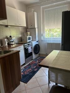 a kitchen with white appliances and a table and a window at Mokka Home in Békéscsaba