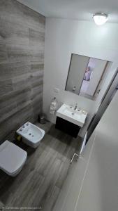 a bathroom with a toilet and a sink and a mirror at Pardelas playa y ballenas in Puerto Madryn