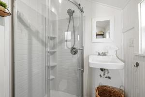 a white bathroom with a shower and a sink at Fisher Flats Downstairs in Cedar Key