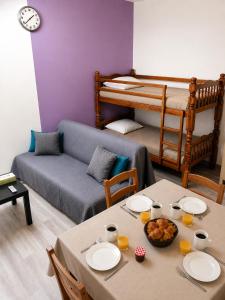 a living room with a table and a bunk bed at L'oiseau bleu in Salin-de-Giraud