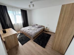 a bedroom with a bed and a large window at Bounty Home in Bistriţa