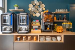 a counter with two coffee machines and plates on it at Nemea Appart Hotel Sunset Nice Arenas in Nice