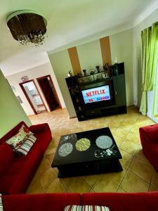 a living room with a red couch and a tv at Peaceful Haven with Pool, Breathtaking View in Oued Laou