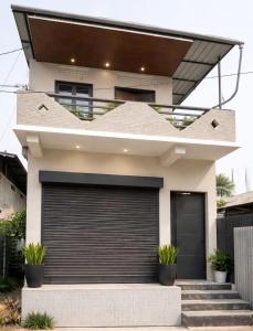 a white house with a garage at The Glory Apartment room 1 in Imphal