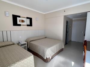 a bedroom with two beds and a tv on the wall at Spazzio Diroma Com acesso ao Acqua Park in Caldas Novas +29 photos