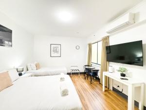 a hotel room with two beds and a flat screen tv at studio Ex hotel room city 107 in Adelaide