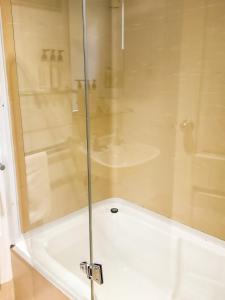 a shower with a glass door in a bathroom at studio Ex hotel room city 107 in Adelaide +5 photos