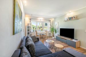 a living room with a blue couch and a flat screen tv at Ferienwohnung Dicke Linde, 55qm in Schmallenberg