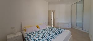 a white bedroom with a bed and a mirror at Vilas Praia de Chaves Deluxe house sol y mar in Rabil