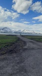 a dirt road with snow covered mountains in the distance at Park Side Hotel Tsalka in Tsalka