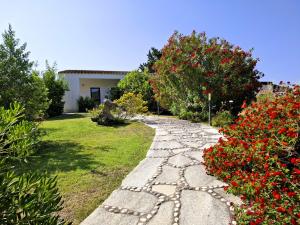 a stone path in a garden with red flowers at Lu Lisandru in Abbiadori