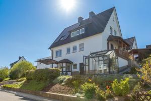 a white house with a black roof at Ferienwohnung Dicke Linde, 55qm in Schmallenberg