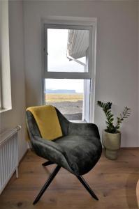 a black chair sitting in front of a window at Stracta Apartments in Kirkjubæjarklaustur