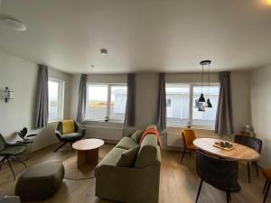 a living room with a couch and a table and chairs at Stracta Apartments in Kirkjubæjarklaustur