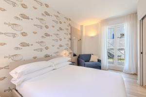 a bedroom with a white bed and a blue chair at Luxury Suites Collection - Ceccarini in Riccione