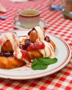 a plate of pastries with fruit and a cup of coffee at Hotel Vacanța in Geoagiu Băi