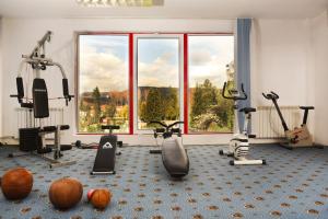 a gym with exercise equipment and a large window at Hotel Vacanța in Geoagiu Băi