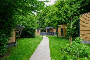 a walkway through a yard with trees and houses at Urban Gardens Ieper in Ieper