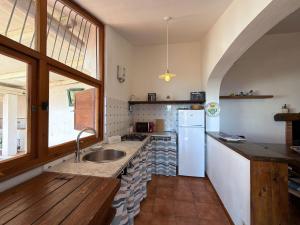 a kitchen with a sink and a refrigerator at Casa Egy - ArgonautiVacanze in Casale Gastagno