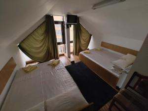 a bedroom with two beds and a window at Hotel Tiver in Câmpia Turzii