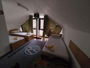 a small room with two beds in a room at Hotel Tiver in Câmpia Turzii +1 photo
