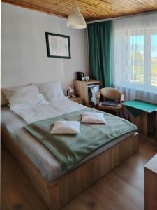 a bedroom with a bed with a green comforter at Willa Perełka in Mielno