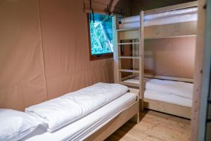 two bunk beds in a room with a window at Urban Gardens Ieper in Ieper