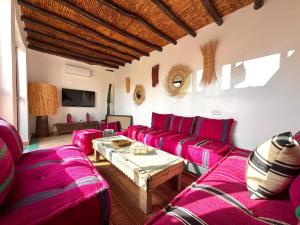 a living room with pink couch and a table at Riad Taww'Ami in Marrakesh