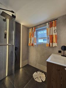 a bathroom with a sink and a shower and a window at Ferienhaus Antoinette in Biberwier +46 photos