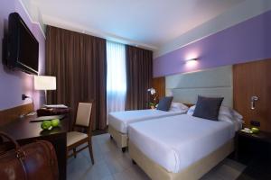 a hotel room with two beds and a desk at My One Hotel Bologna in Bologna +39 photos