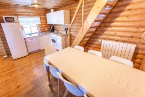 a kitchen and dining room with a table and chairs at Brimnes Bungalows in Ólafsfjörður +15 photos