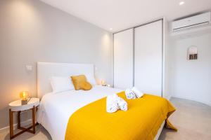 a bedroom with a yellow bed with towels on it at #081 1BR Vale Mangude Pool & Location in Albufeira +28 photos