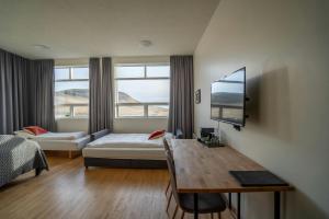 a hotel room with a bed and a desk and a tv at Volcano Hotel in Vík