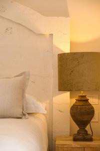 a lamp sitting on a table next to a bed at Masseria San Francesco in Savelletri di Fasano