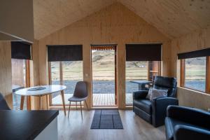 a living room with a couch and a table and chairs at Paradise Cottages in Vík