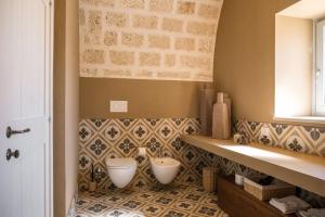a bathroom with two bowls on a tiled floor at Masseria San Francesco in Savelletri di Fasano +125 photos