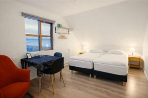 a bedroom with a bed and a desk and a window at Malarhorn Accommodations in Drangsnes
