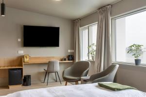ein Schlafzimmer mit einem Bett und einem Fernseher an der Wand in der Unterkunft Stracta Hotel Mosfell in Hella