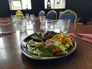 a plate of food with a salad and french fries at Hotel Studlagil in Skjöldólfsstaðir