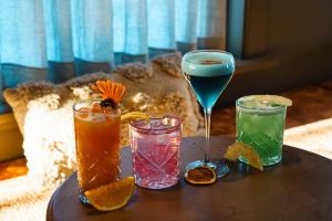 a table with three different colored drinks on it at Hotel Grimsborgir by Keahotels in Ásborgir