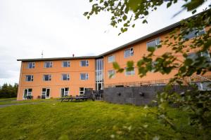 an orange building with a bench in front of it at Hotel Hallormsstadur in Egilsstaðir
