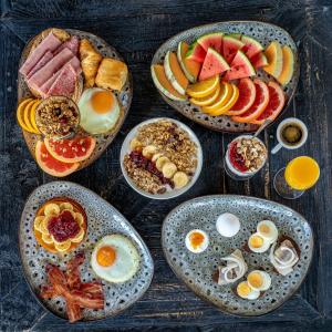 a table with plates of breakfast food on it at Litli Geysir Hotel in Haukadalur