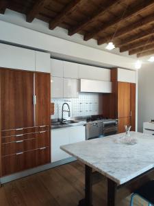 a kitchen with white cabinets and a marble table at La Contrada - Suite Apartment in Sarnico