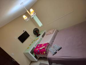 a small bedroom with a bed and a shelf at Pousada Girassol in Rio de Janeiro