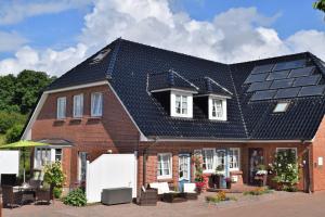 ein Haus mit Sonnenkollektoren auf dem Dach in der Unterkunft Freie Sicht - Das Nordsee-Gesundheitshaus 1 in Dagebüll